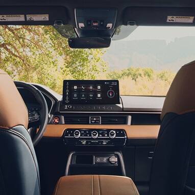 2027 Honda Passport TrailSport Elite dashboard with infotainment screen and brown leather front seats (Mid-Size SUV).